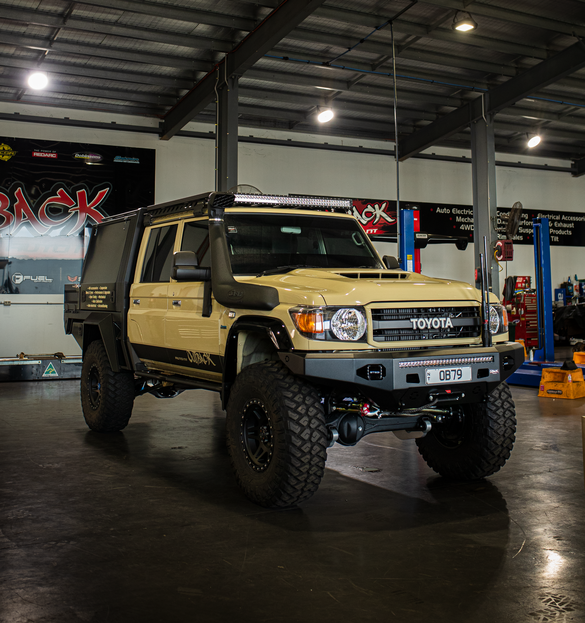 Lifted Toyota truck parked outside a modern building entrance.  — Outback Auto NT in Berrimah, NT