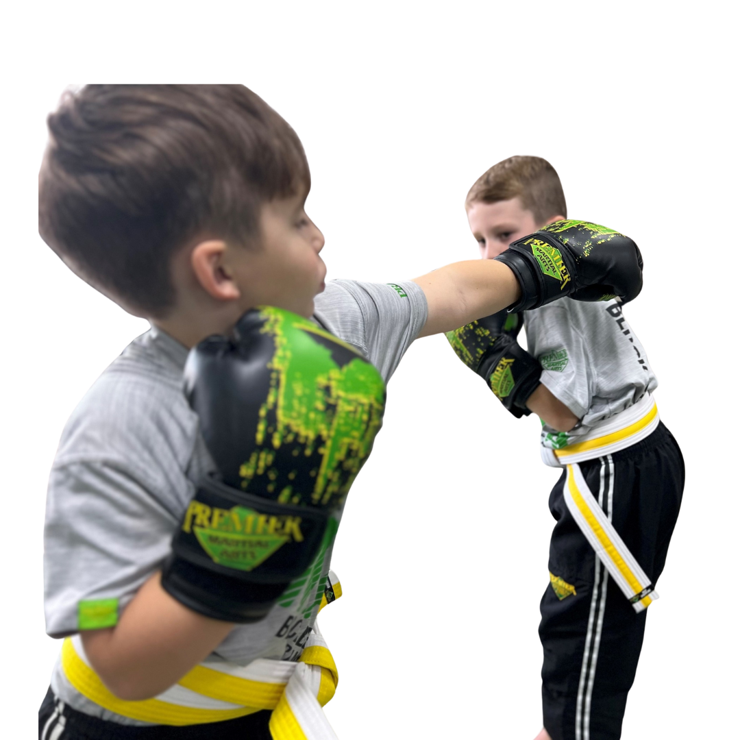 A boy and two girls are wearing karate uniforms and pointing at the camera