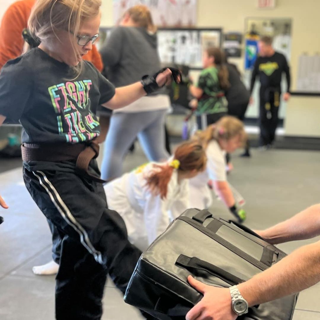 A boy and a girl are practicing taekwondo together.