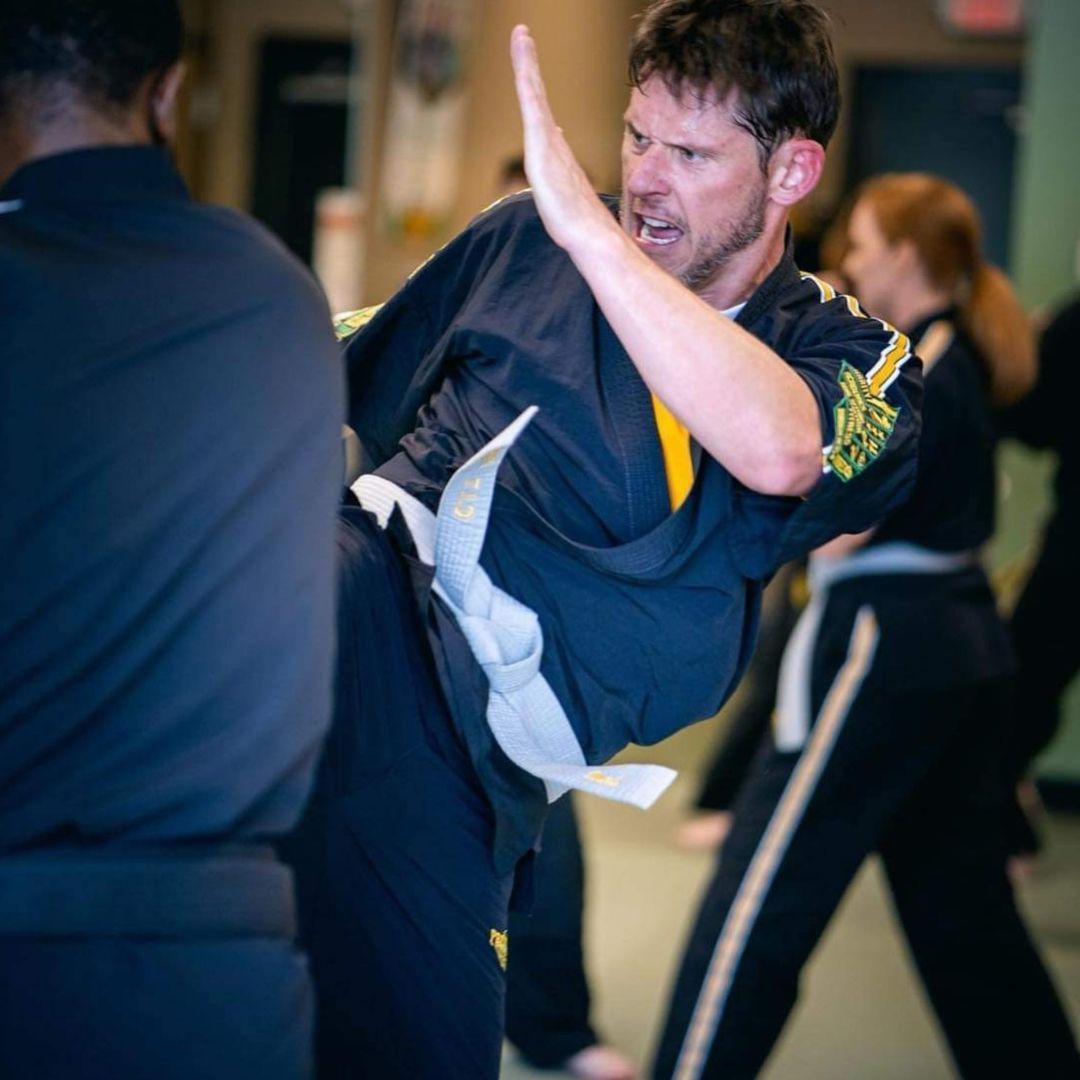 A group of men are practicing karate in a gym.