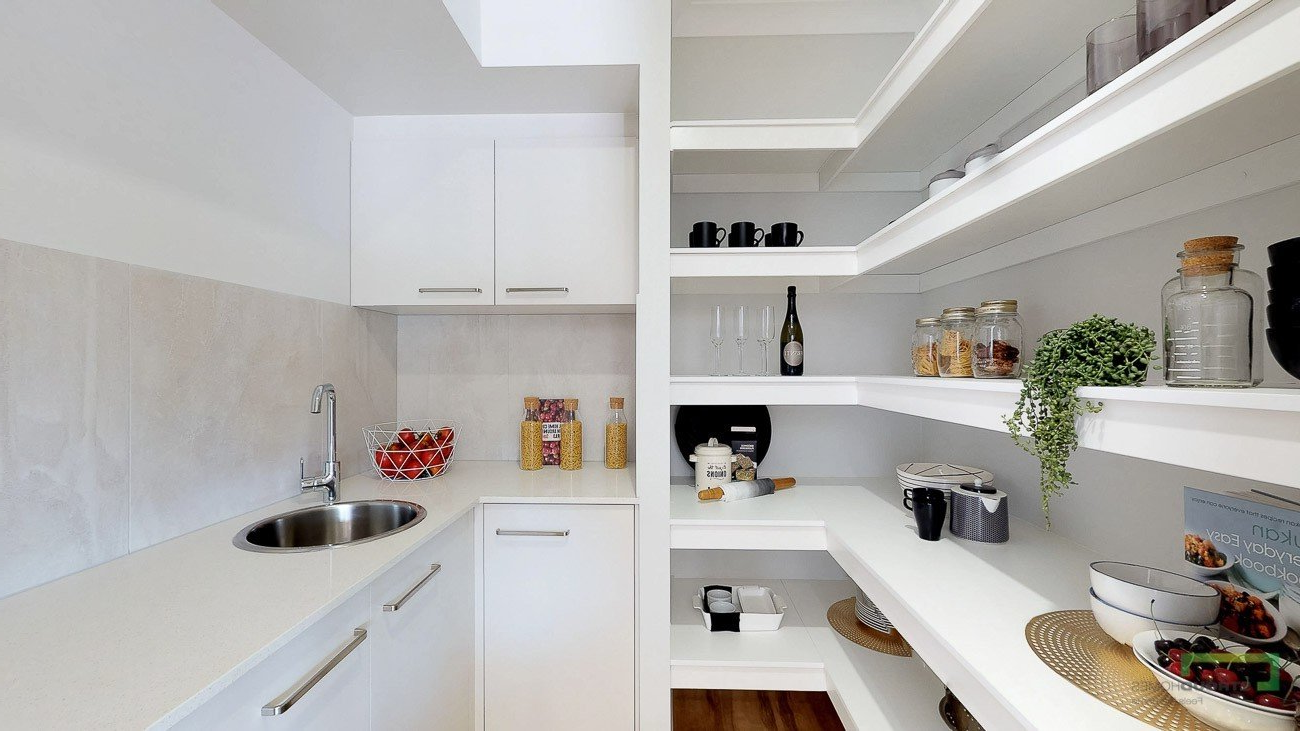 White pantry with shelves and counter, sink, and various food items.