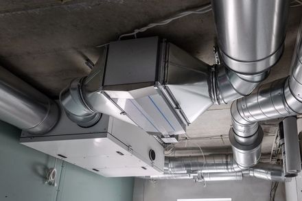 Ceiling ductwork and ventilation system with silver metal pipes in an industrial interior