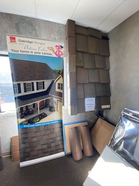 Display of roofing shingles and a promotional banner in a showroom.