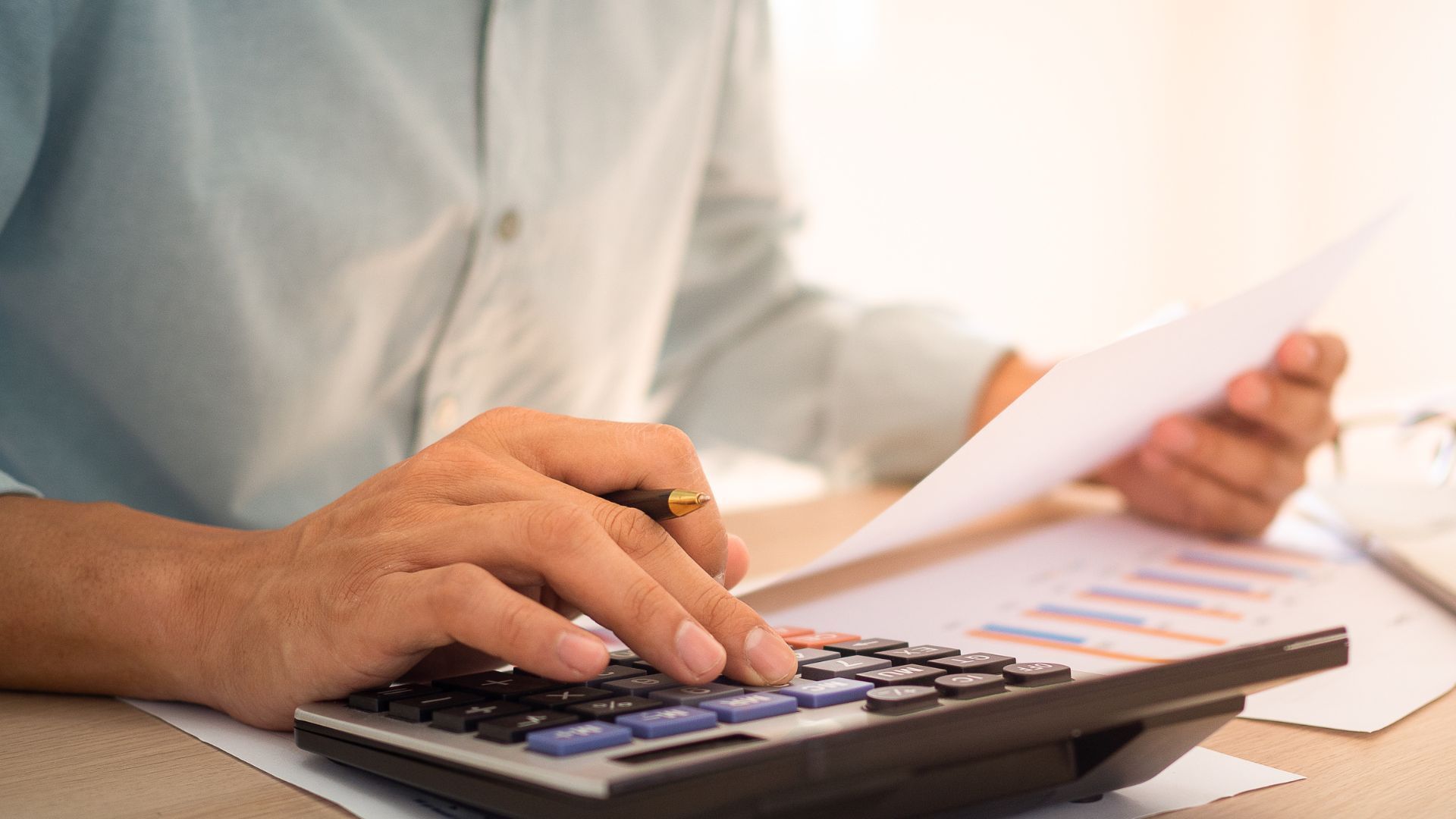 Contractor reviewing a budgeting spreadsheet on a laptop.