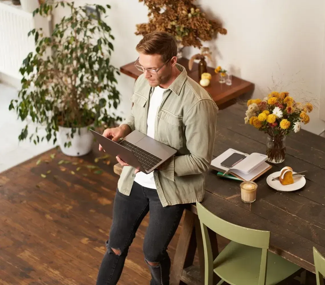 Person reviewing a clipboard beside a table with coffee and flowers in a bright room