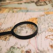 Magnifying glass on a map, highlighting detailed geographic lines and labels