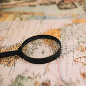 Magnifying glass on a map, highlighting detailed geographic lines and labels