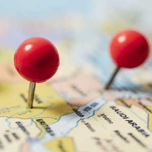 Two red pushpins marking locations on a map, one near Saudi Arabia.