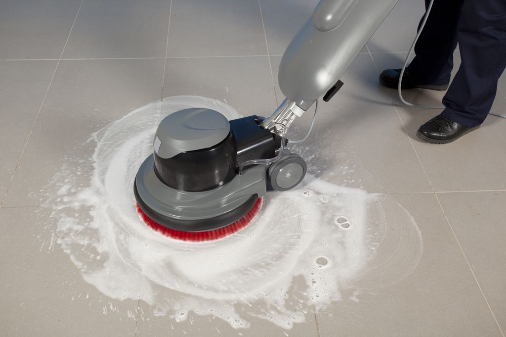 Floor-cleaning Machine Scrubbing a Gray Tile Floor — Your Local Handyman in the Darling Downs, QLD