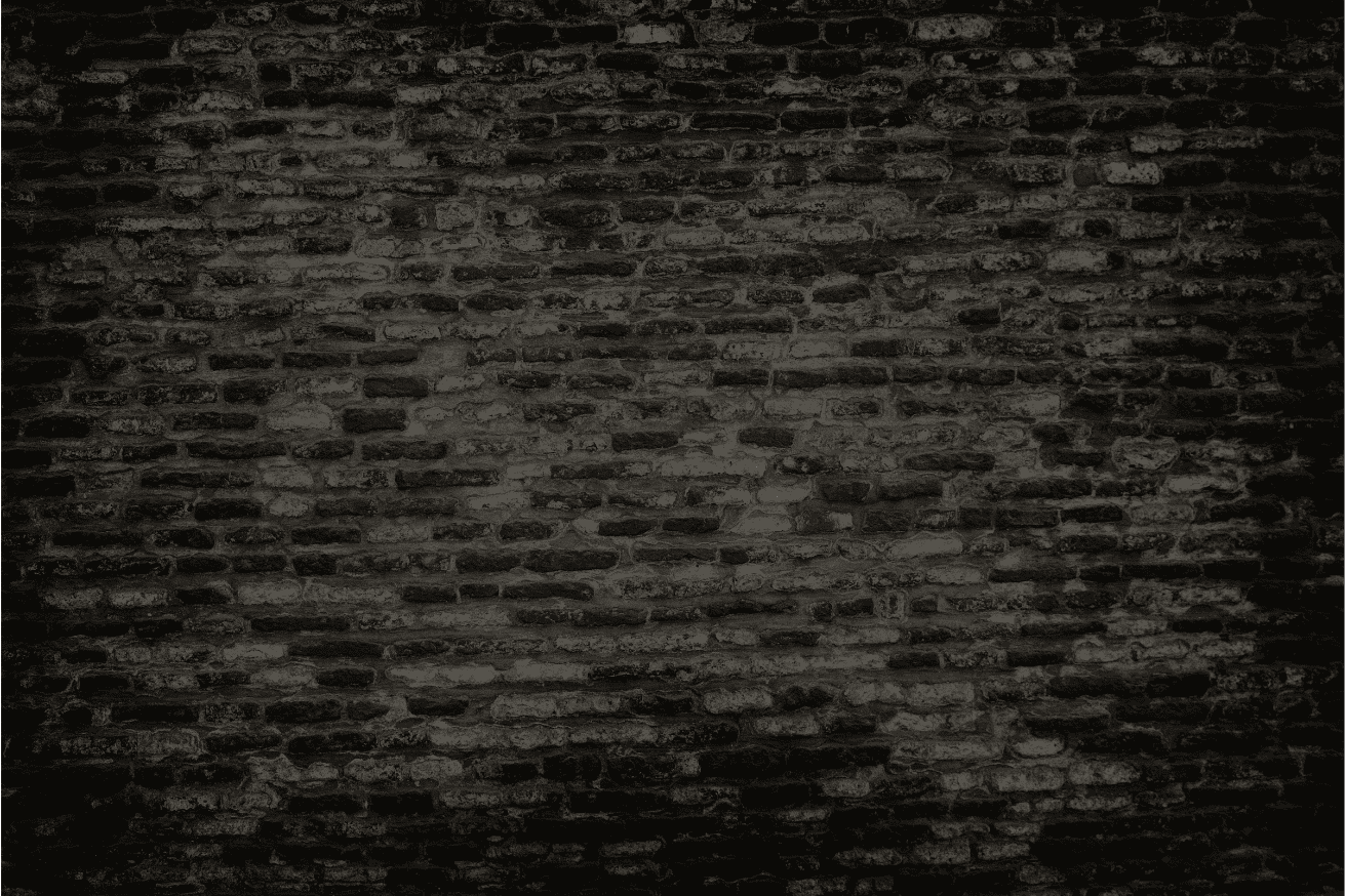 Dark, weathered brick wall with a black grunge texture.