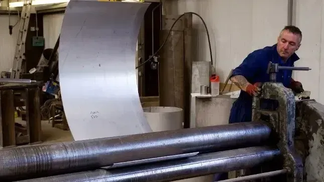 A man is working on a machine in a factory.