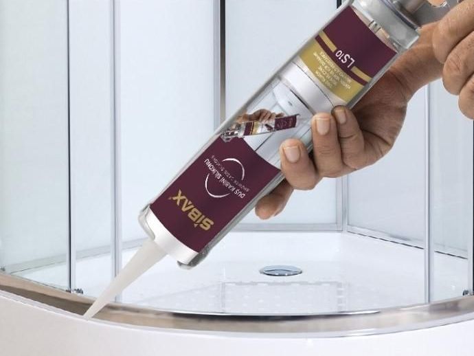 A person is holding a bottle of sibax sealant