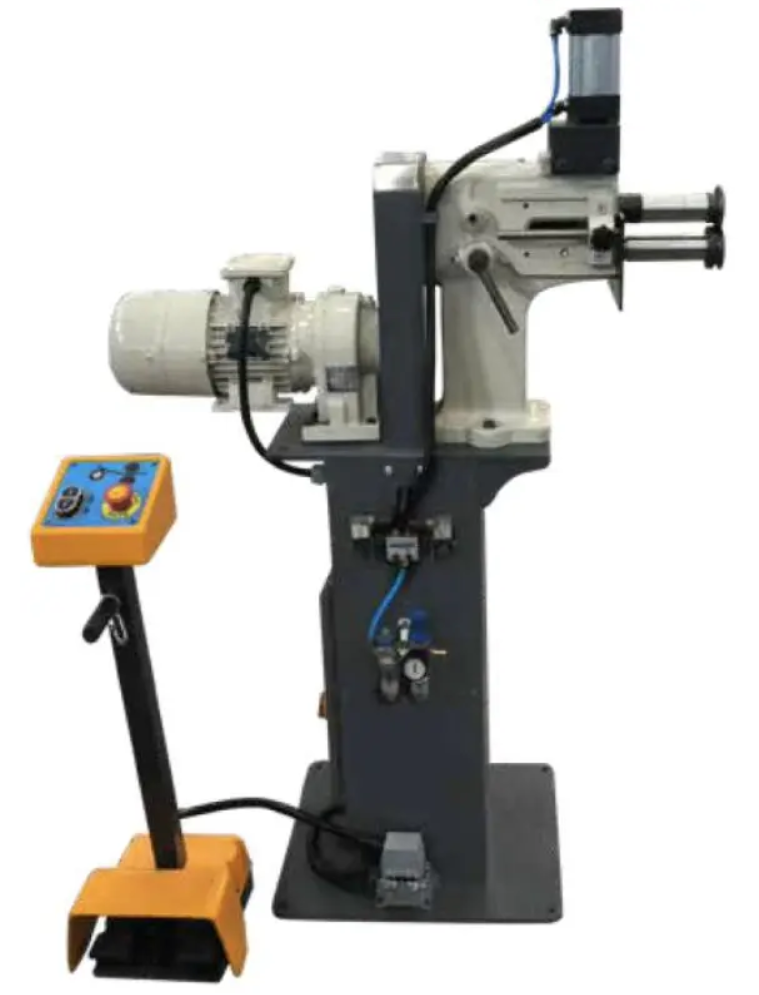 A machine is sitting on a stand next to a control panel.