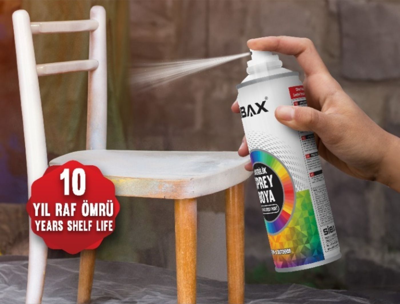 A person is spraying a can of paint on a chair