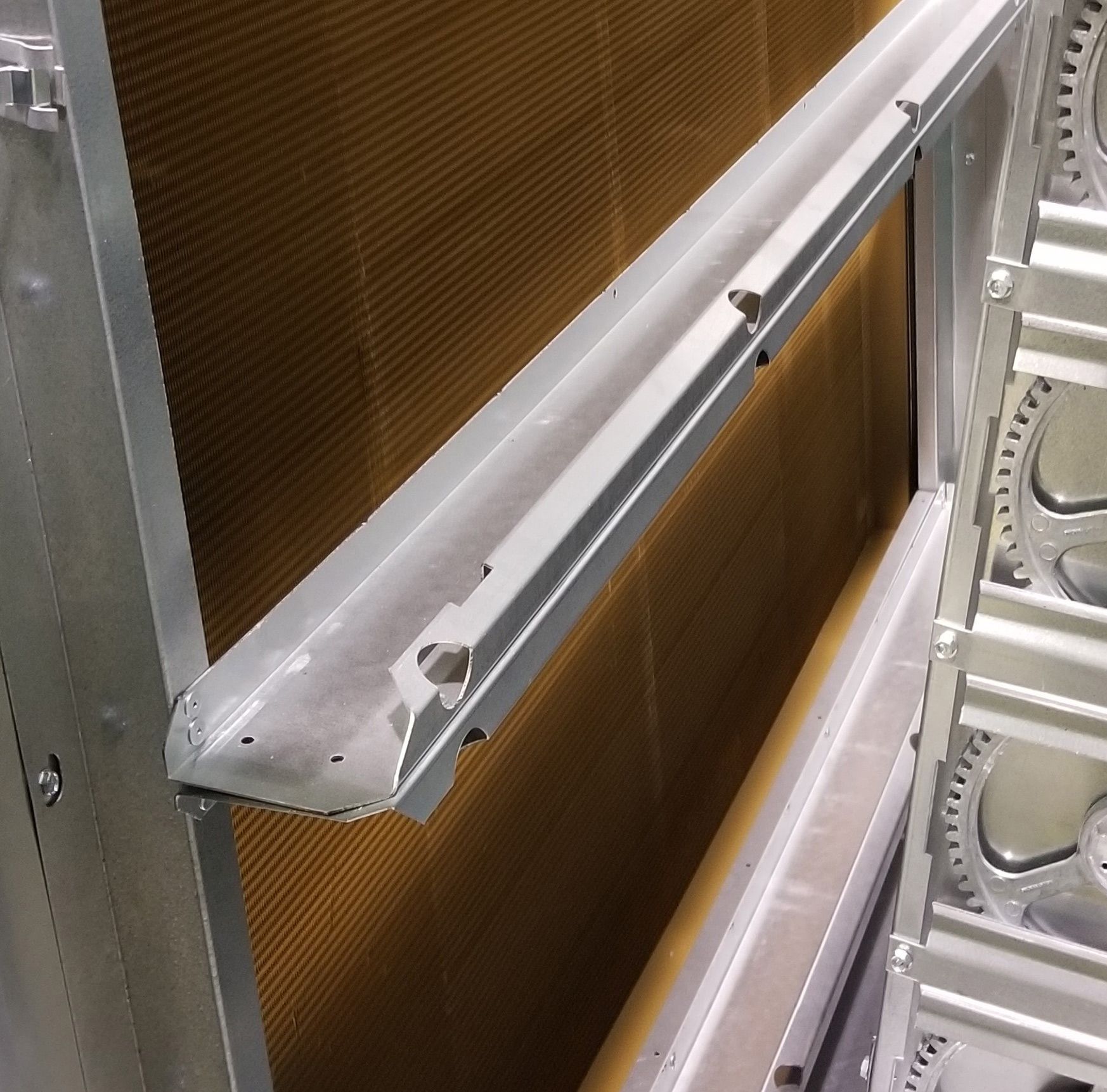 Close-up of a metallic frame with brown mesh panels and silver industrial hardware.