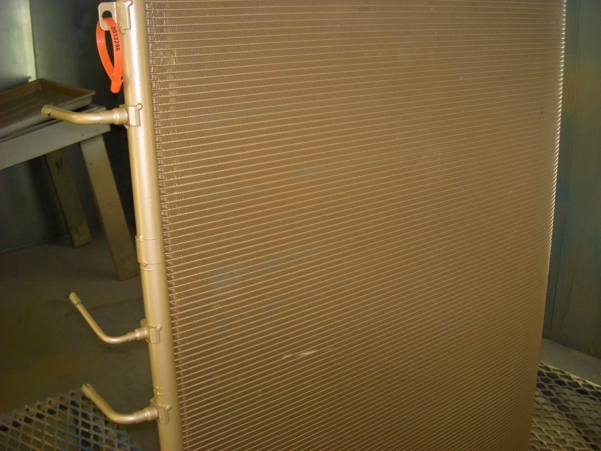 Metal industrial panel with textured surface and side handles in a workshop setting