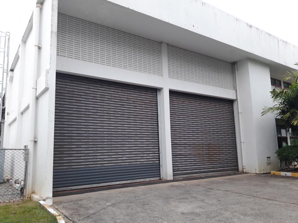 A Large White Building With a Lot of Garage Doors — Mackay Garage Doors in Andergrove, QLD