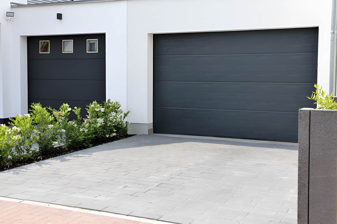 There Are Two Garage Doors in Front of a House — Mackay Garage Doors in Andergrove, QLD