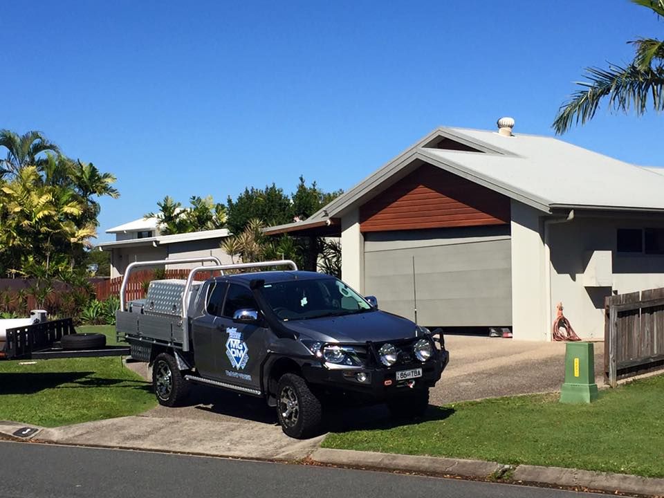 A Black Truck is Parked in Front of a House — Mackay Garage Doors in Andergrove, QLD