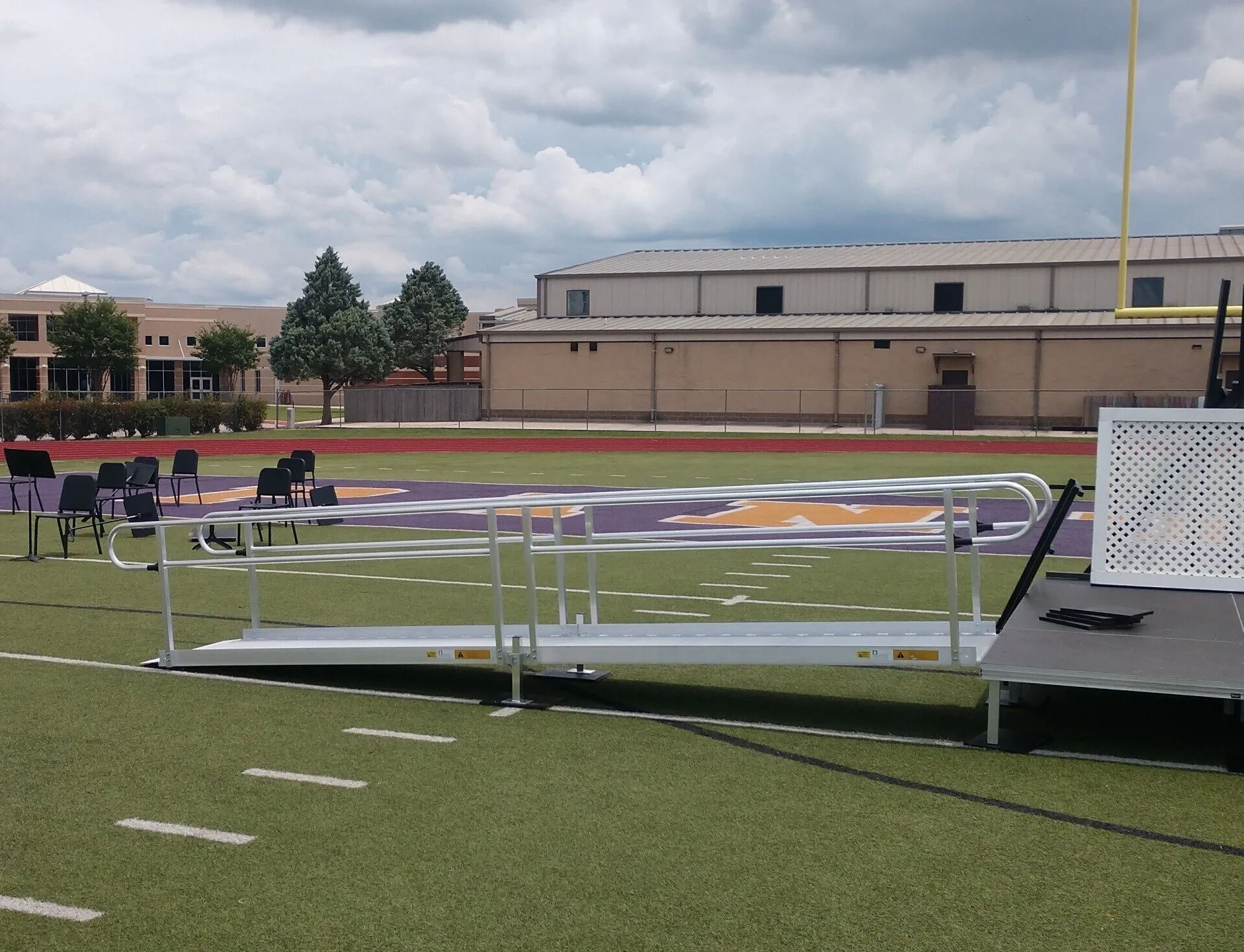 A ramp with handrails on a football field, possibly for accessibility.