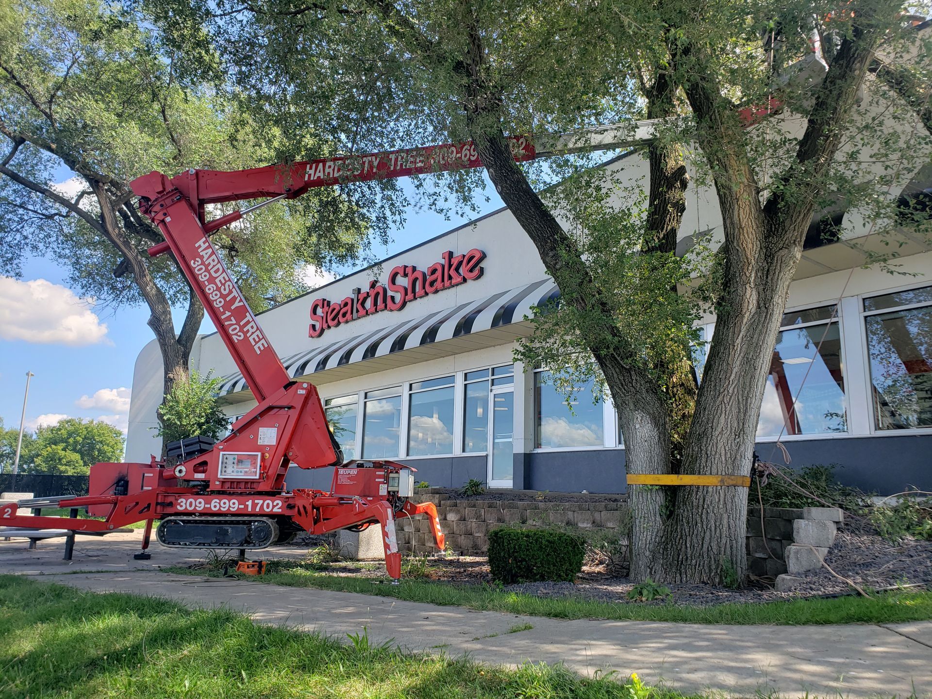 A red crane is sitting in front of a building.