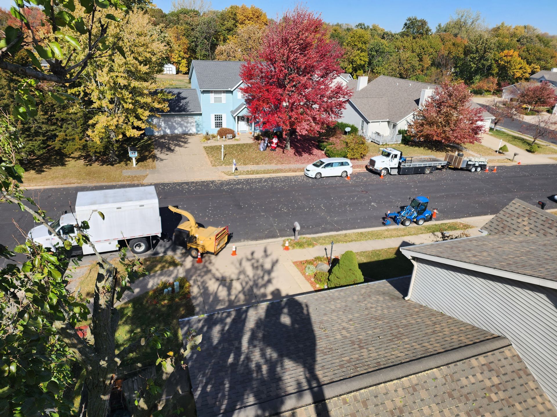 An aerial view of a residential neighborhood with a white truck parked on the side of the road