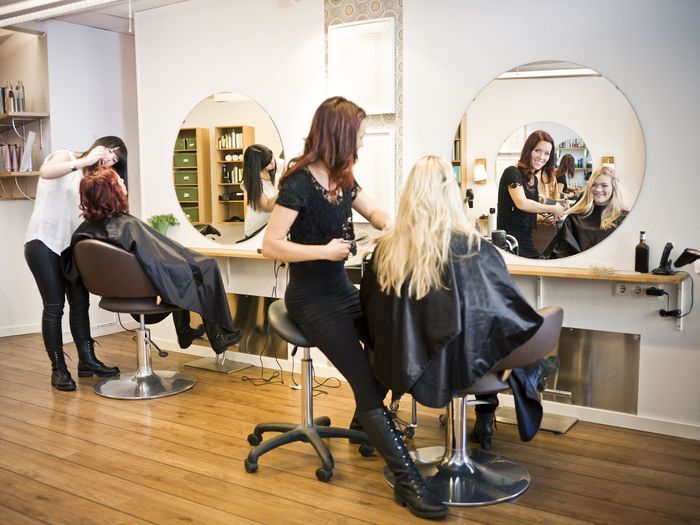 A woman is getting her hair cut in a hair salon.