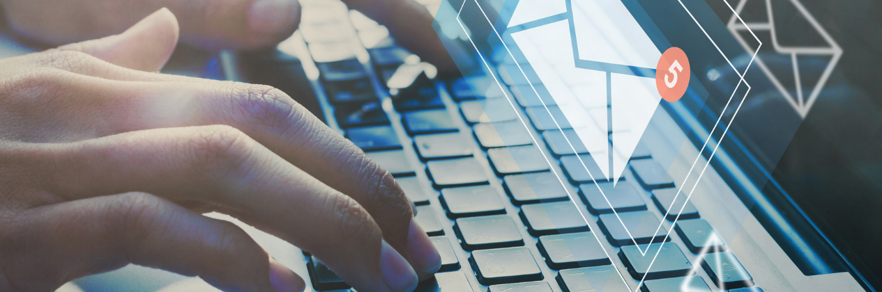 A person is typing on a laptop computer with an envelope coming out of the screen.