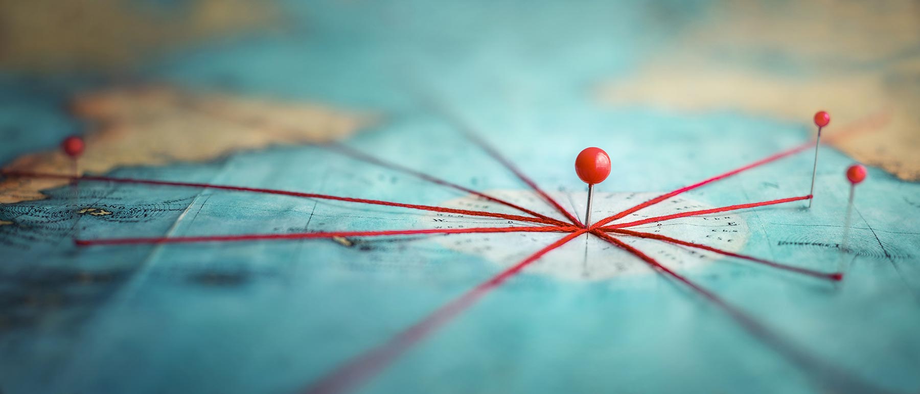 Stylized network map with red nodes and lines on a teal background