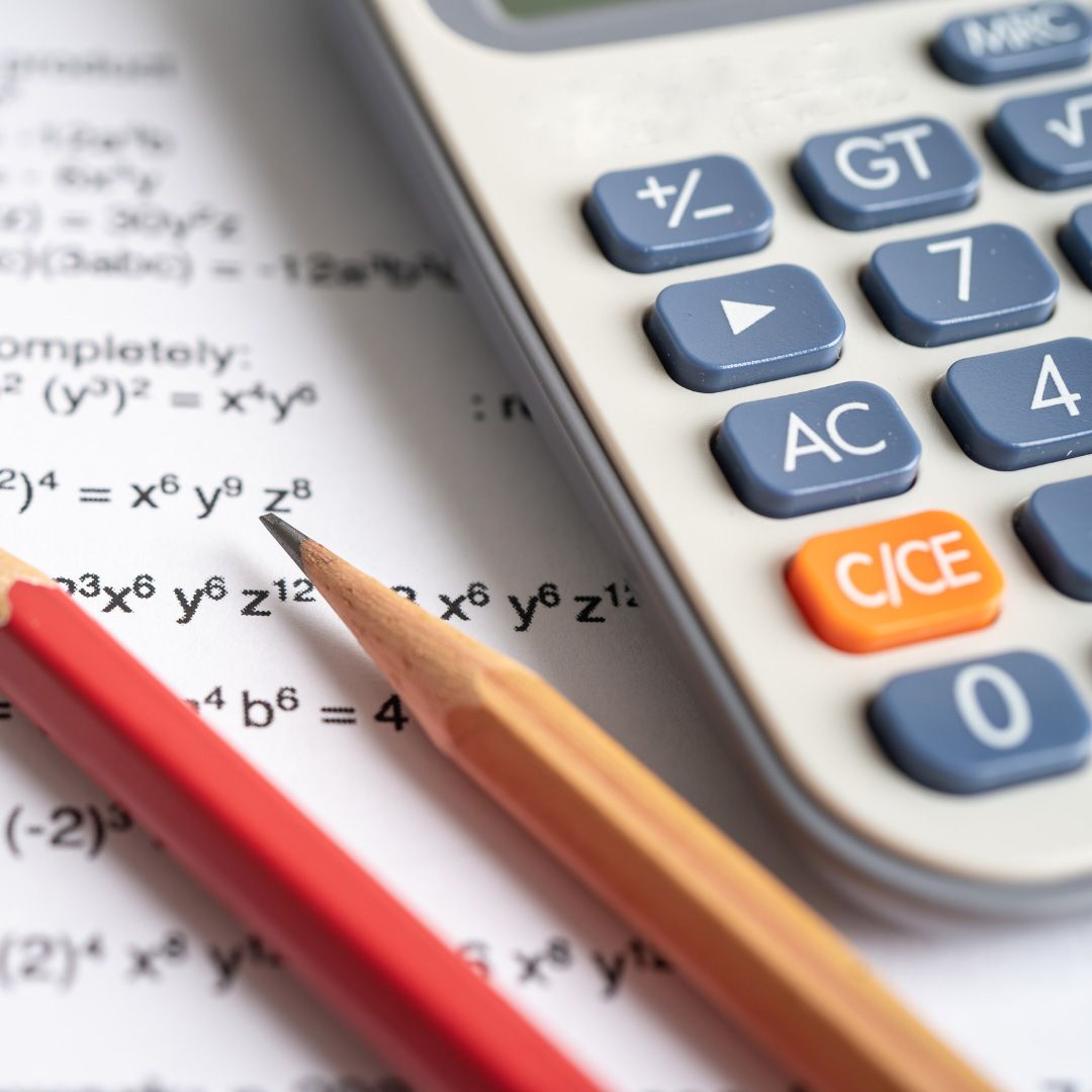a calculator sits on a piece of paper next to two pencils