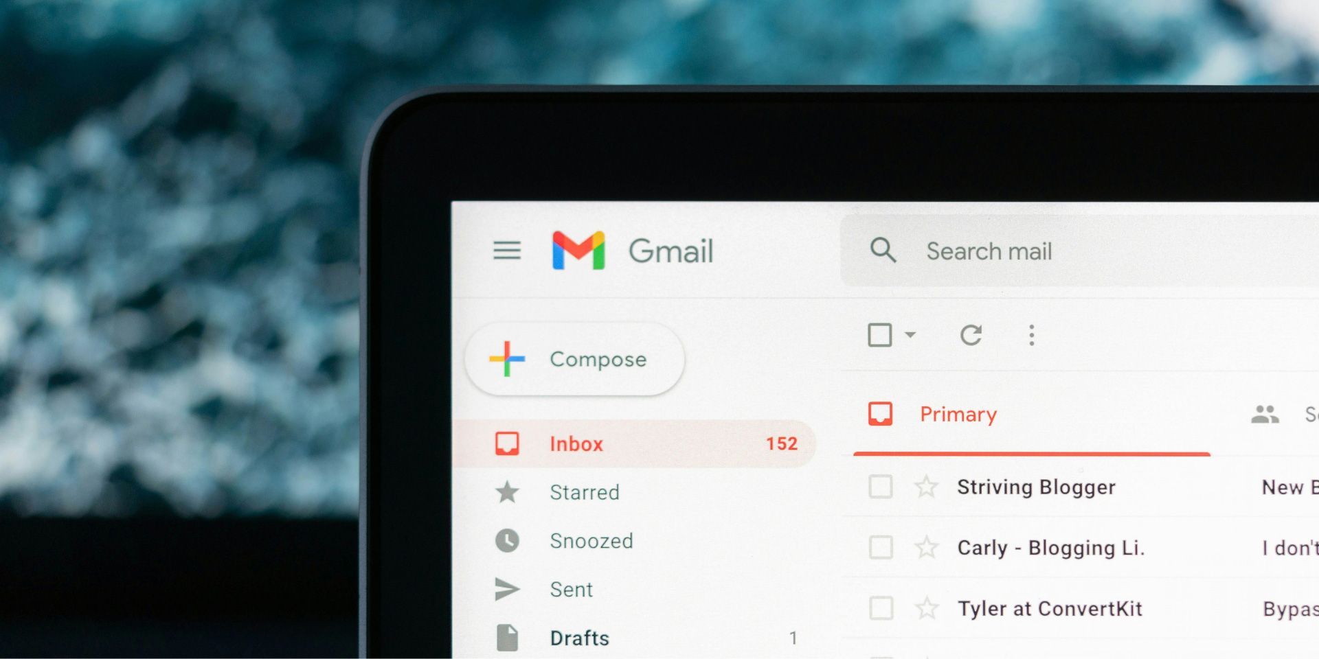 Laptop screen showing Gmail inbox with a white interface and left sidebar menu.