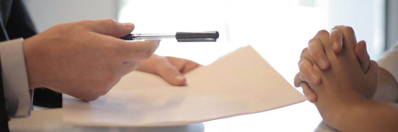 a person handing an agreement over to another person