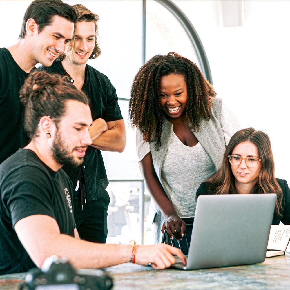a group of people are looking at a laptop computer .