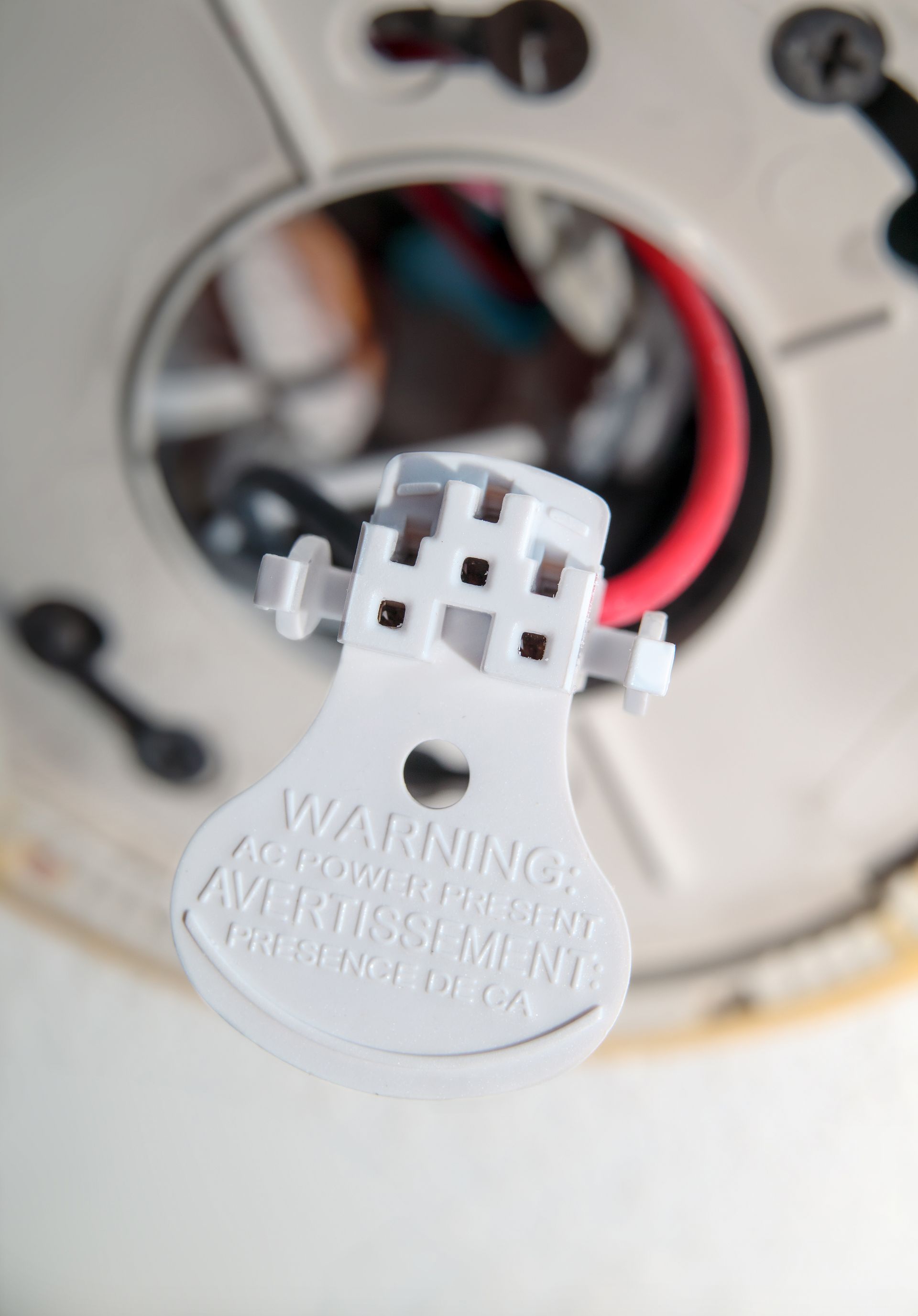 Close-up of a white plastic electrical connector with wires inside a device housing