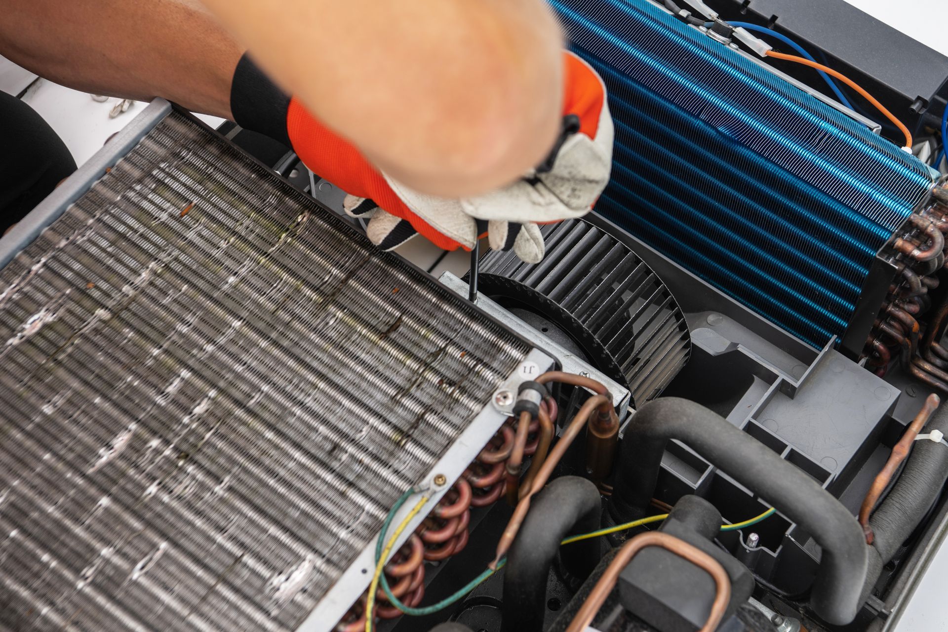 Person wearing gloves removing a car cabin air filter during engine maintenance