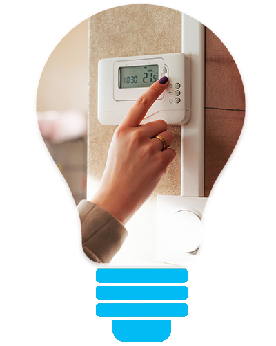 Hand adjusting a wall thermostat display near a window