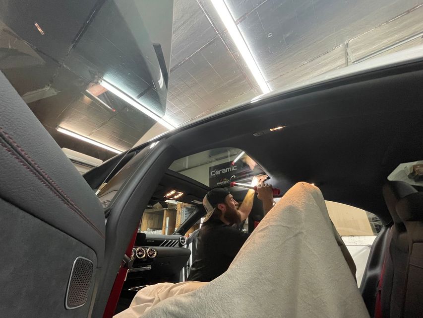 A man is sitting in the driver 's seat of a car.