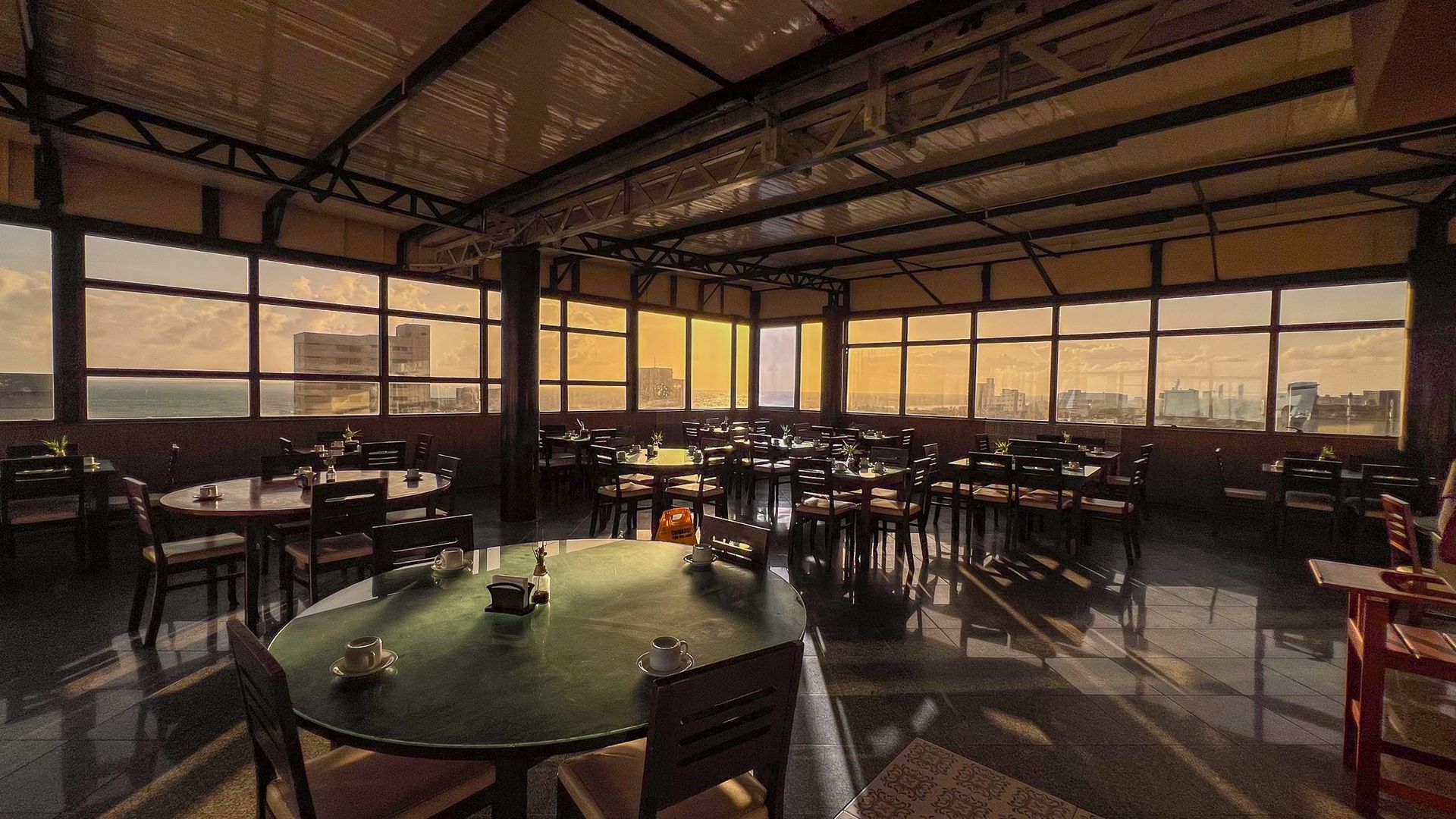 Um restaurante com mesas e cadeiras e uma grande janela-Boreas-Apart-Hotel