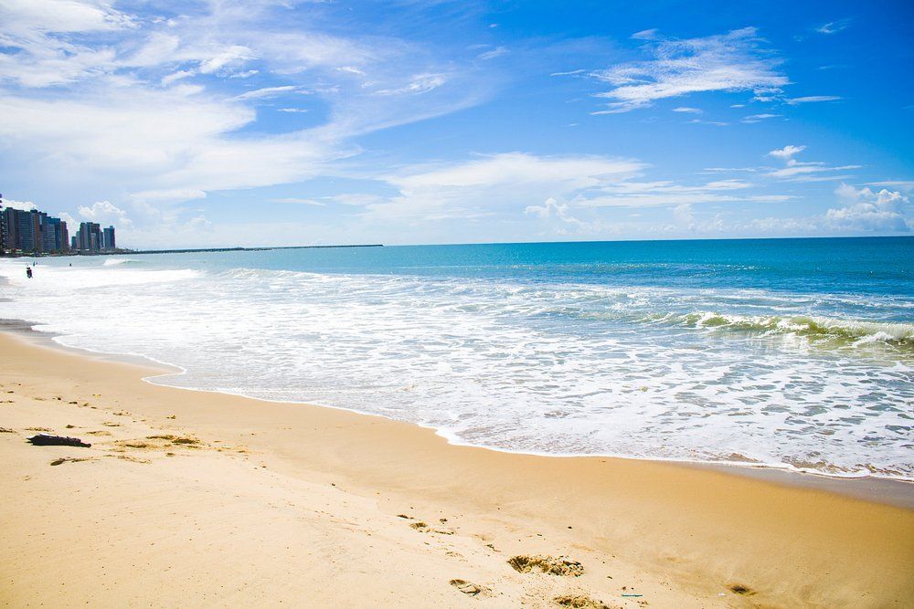 Há pegadas na areia da praia perto do oceano.-Boreas-Apart-Hotel