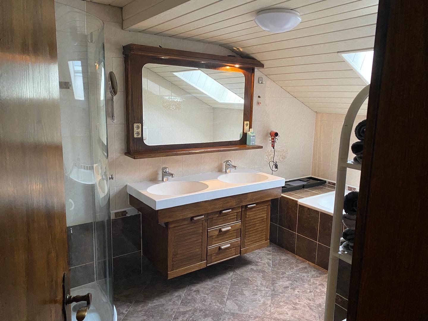 Een badkamer met twee wastafels, een spiegel en een ligbad.