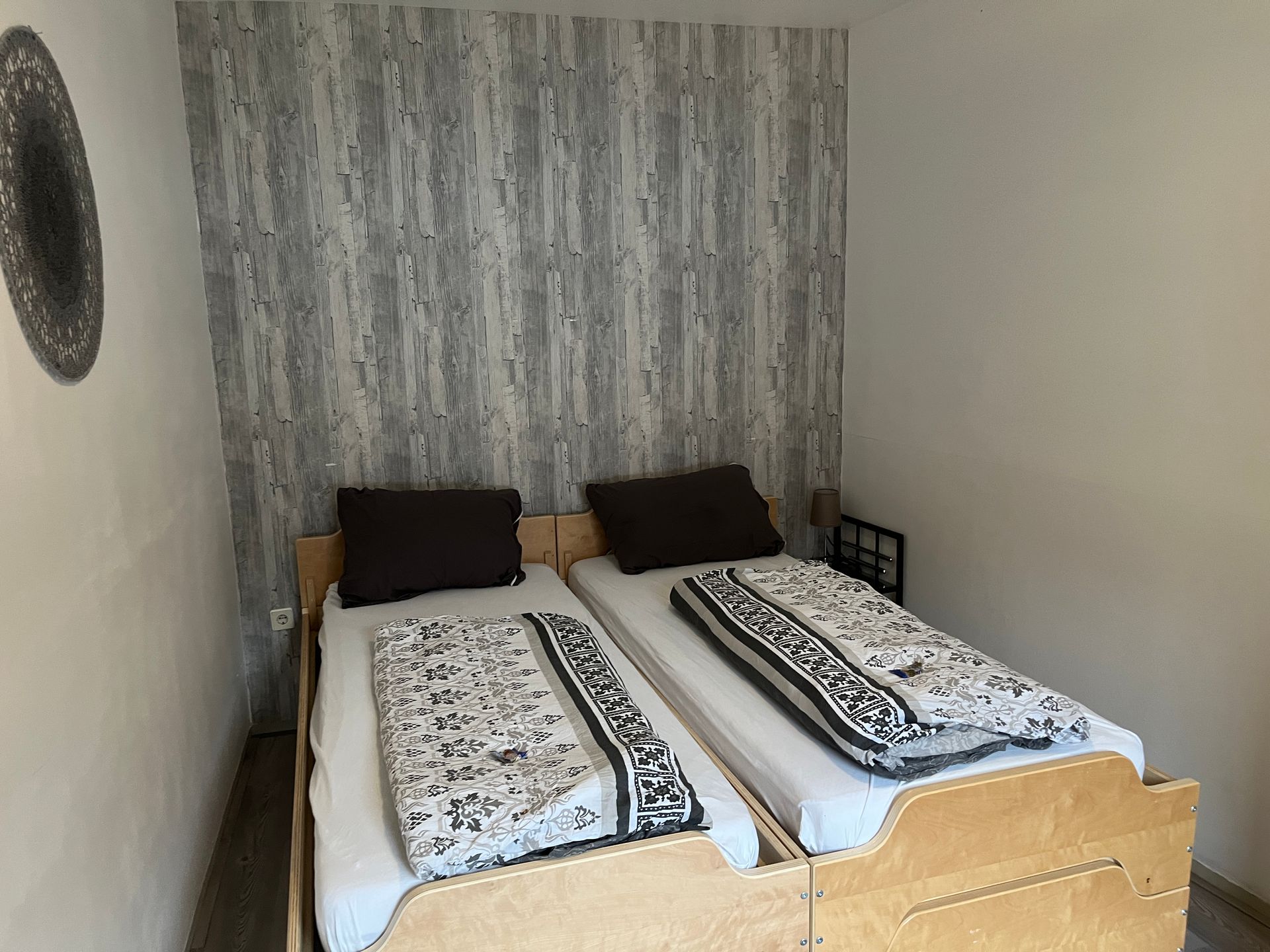 Een slaapkamer met twee bedden en een spiegel aan de wand.