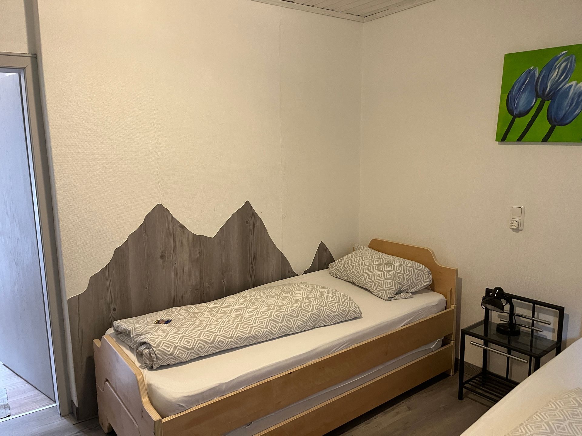 Een slaapkamer met twee bedden en een schilderij aan de muur.