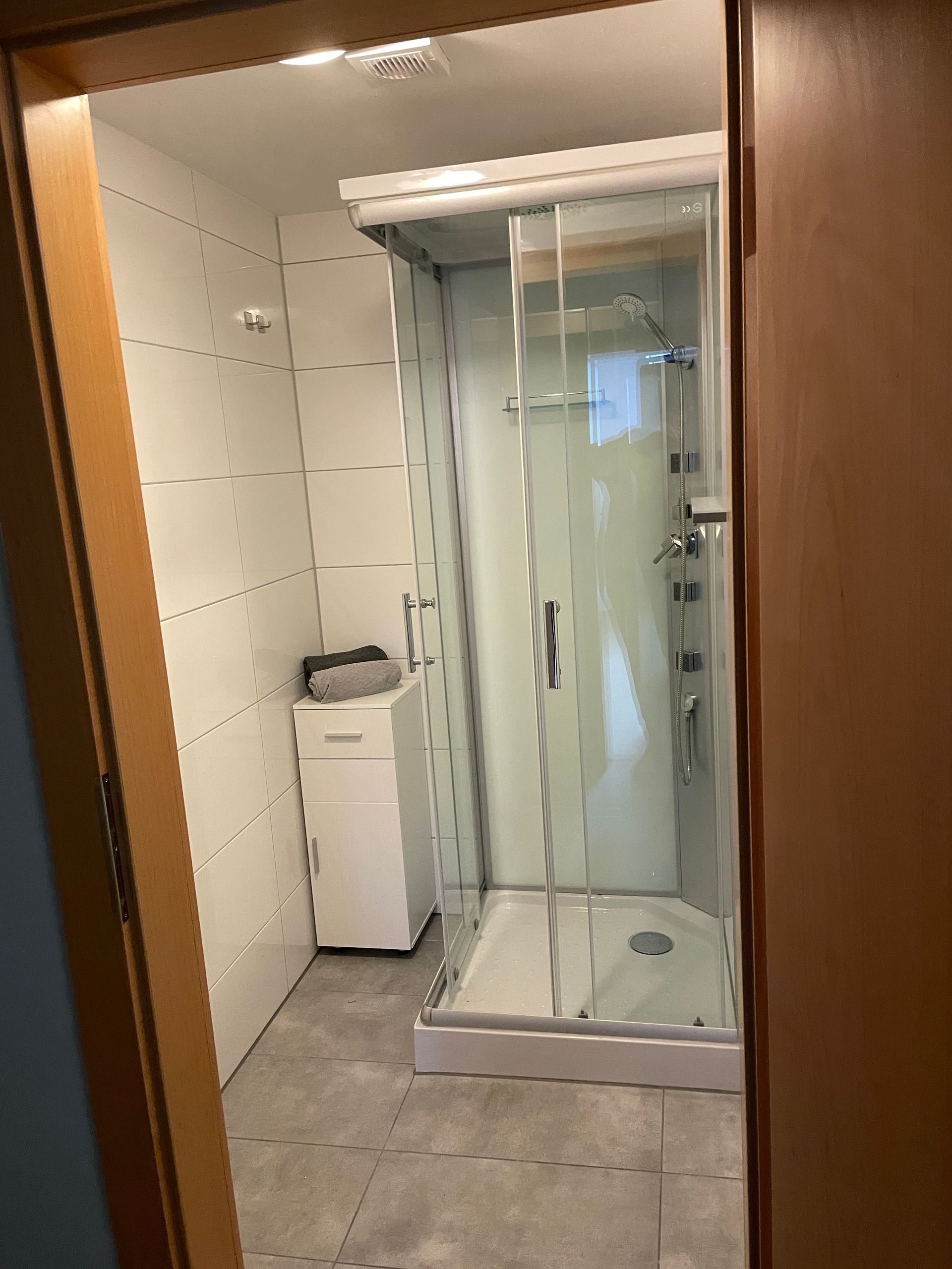 Een badkamer met douche en wasmachine