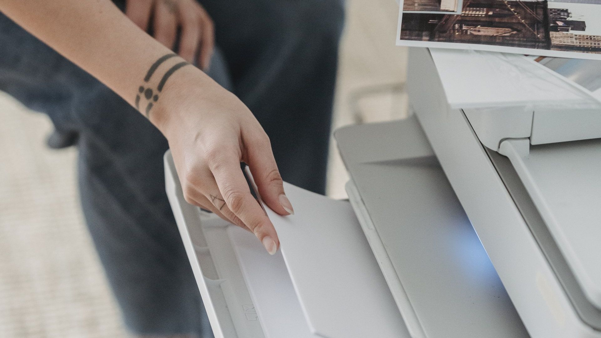 A person is using a printer to scan a piece of paper.