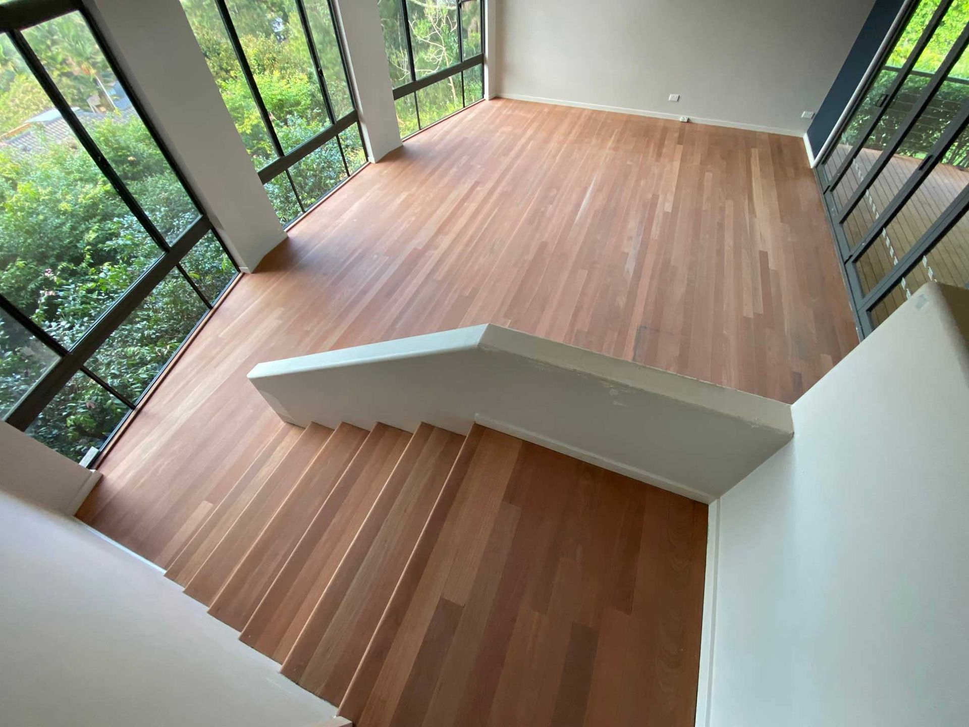 An Empty Room With A Sanded Wooden Floor And Stairs 