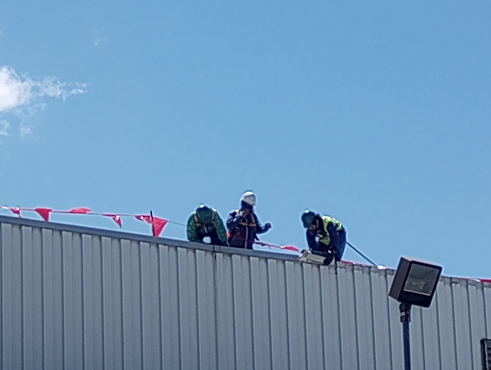A group of MP Environmental employees are working on the roof of a commercial building.