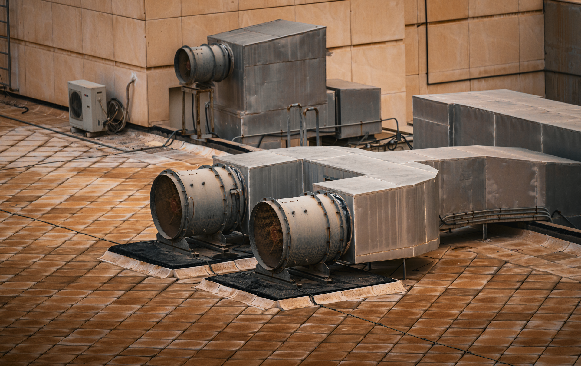 Rooftop HVAC ductwork and ventilation equipment on a commercial building before heating season.