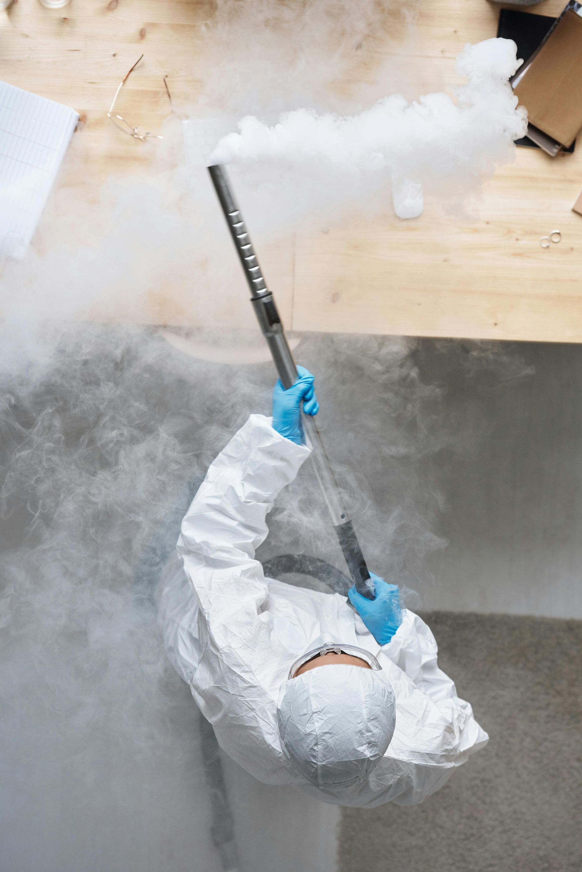 Person in a protective suit spraying a dry ice blaster to remediate a commercial building.