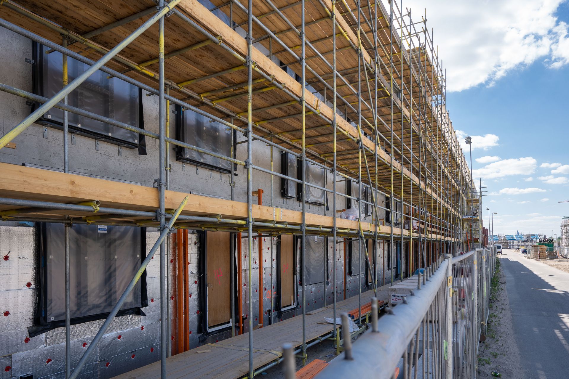 Scaffolding lines the exterior of a commercial building during a large-scale renovation project.