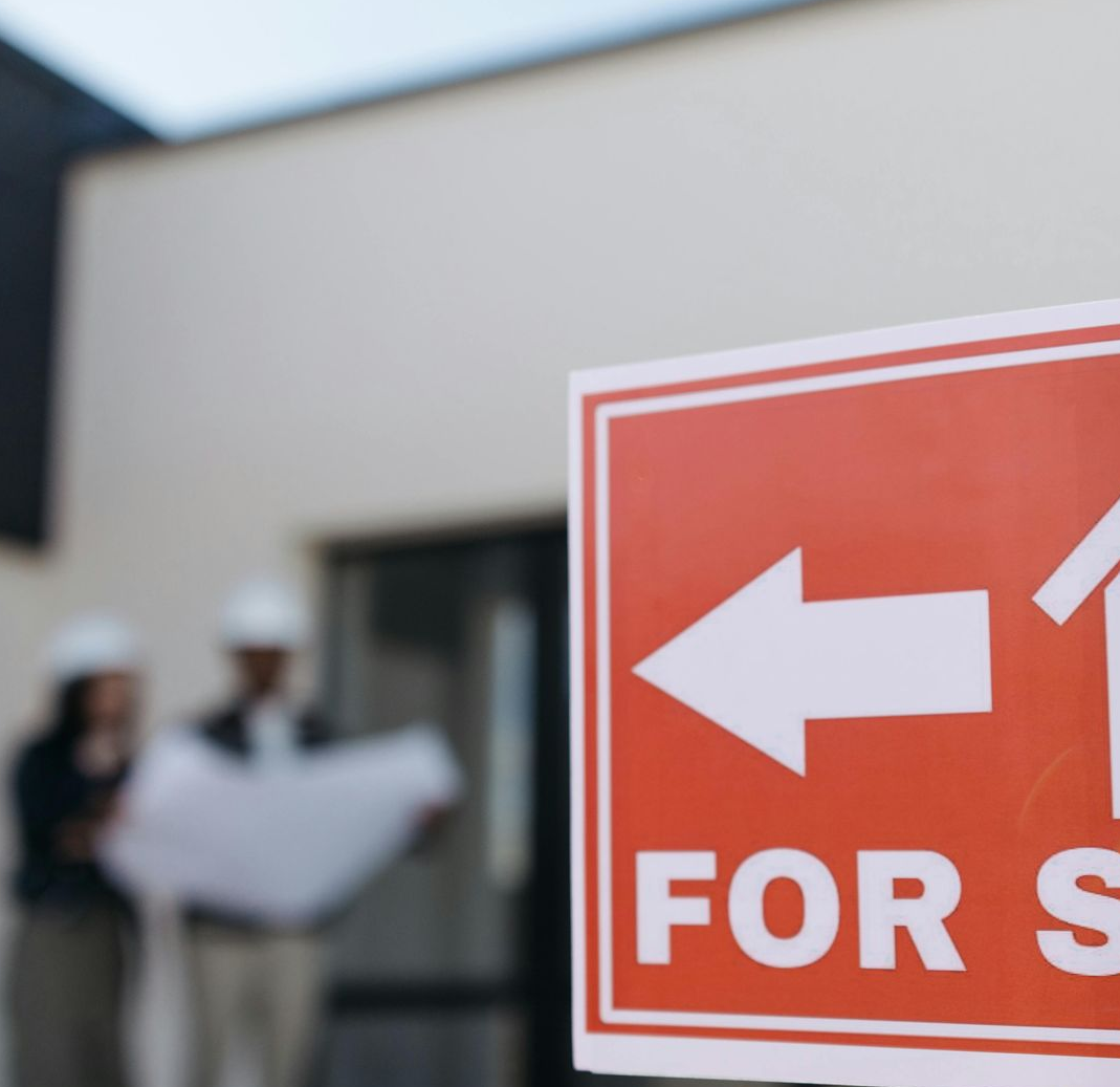 Property for sale sign outside a building as buyers review plans during environmental due diligence.